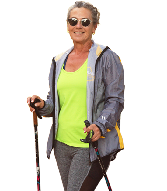 Señora alegre con bastones de marcha nordica.